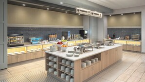Una cocina moderna con una isla central, espacio tipo buffet y un salpicadero de ladrillo.