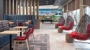 Un interior de restaurante moderno con arreglos de asientos, una mesa de billar y un mural de Spring Hill, Tennessee.
