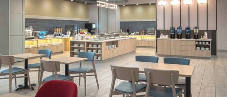 A modern cafe with a central counter, seating area, and a coffee station.