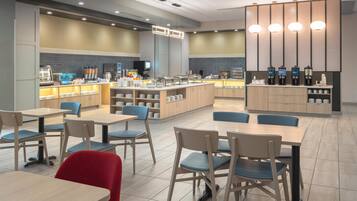 Un café moderne avec un comptoir central, un espace salon et un coin dédié à la préparation du café.