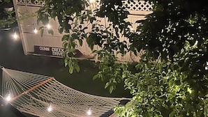 A hammock with lights, a fence, and a sign reading "Dunn Creek Drive". - Steps from University –  3BR, Sleeps 6, FirePit Backyard Concerts & GameDay (Missoula)