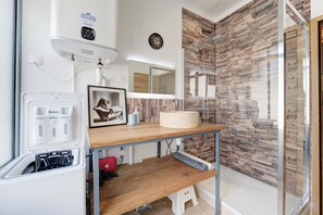 Une salle de bain moderne équipée d’une douche, de toilettes, d’un lavabo et d’un miroir.