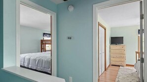 Un dormitorio con cama, cómoda y televisor.