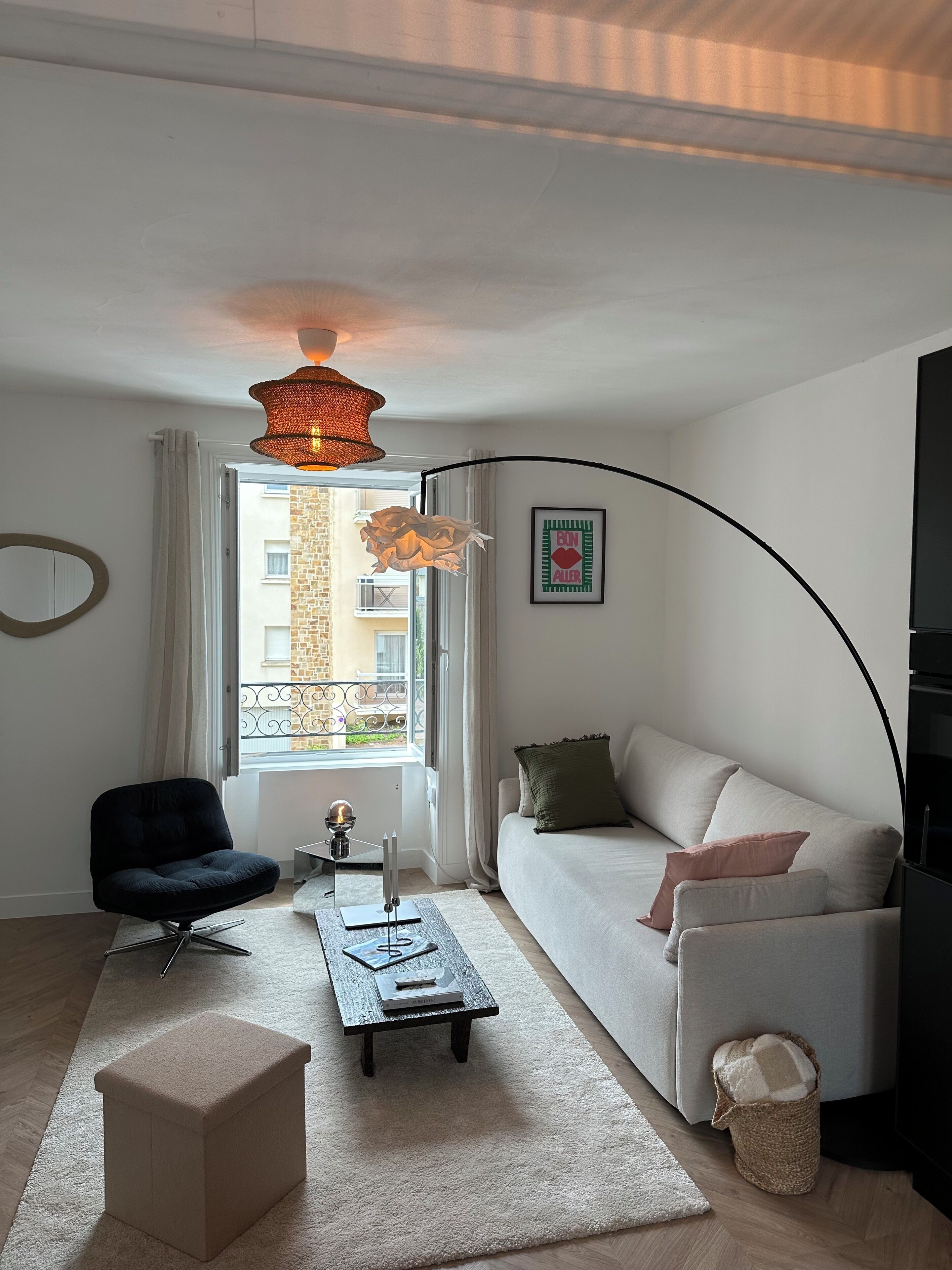 Una sala de estar moderna con un sofá, un sillón, una mesa de centro y una lámpara.