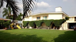 A two-story house with a well-maintained lawn and a children's play area with a slide. - Excellent place to rest!!! (Cuernavaca)