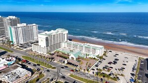 Un hôtel situé sur la côte, composé de plusieurs bâtiments, doté d’un parking et offrant une vue sur la plage.