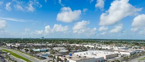 A commercial area with a large building, parking lots, and a clear blue sky.
