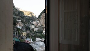 Vista da janela com vista para uma colina e edifícios.