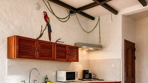A kitchen with wooden cabinets, a microwave, a toaster, and a hanging plant.
