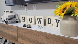 A desk with a television, a vintage toy truck, and a vase with sunflowers. - Northgate Studio - 1 block from TAMU! (College Station)