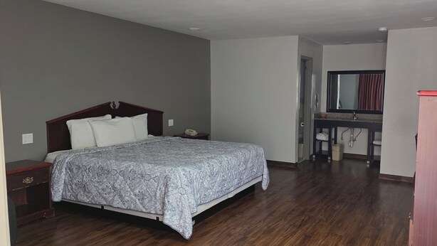 A bedroom with a bed, bedside table, and a desk with a chair.