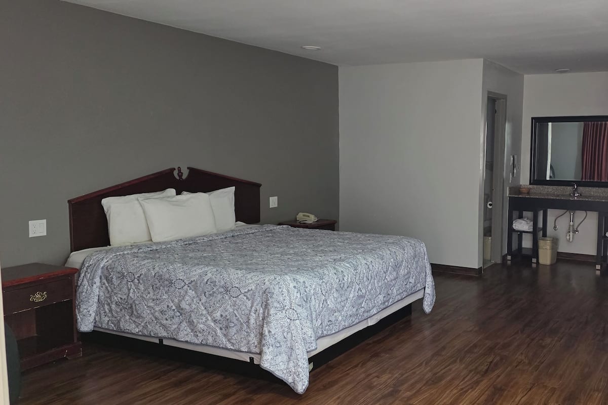 A bedroom with a bed, bedside table, and a desk with a chair.
