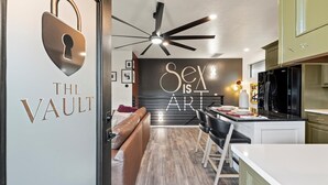 A modern kitchen with a statement wall, a dining area, and a living space.