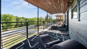 Zona relax all'aperto coperta, con vista su una strada e sul verde.