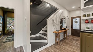 A modern interior with a staircase, a kitchen area, and a dining space.
