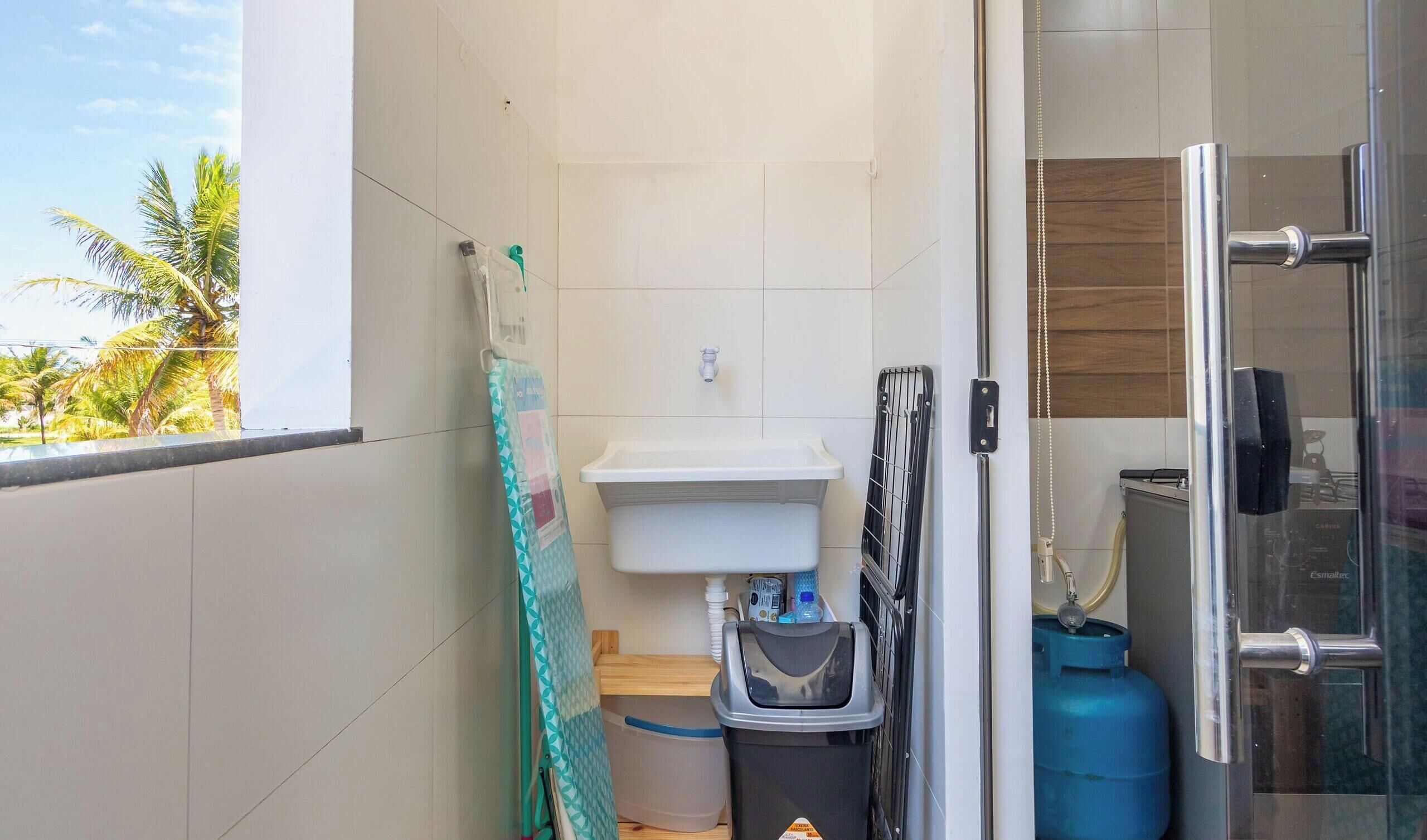 A bathroom with a sink, a shower, and a glass door leading to a balcony.