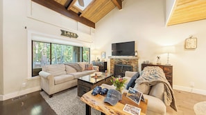 A living room with a sofa, coffee table, fireplace, and a sign indicating 'LAKE TAHOE'. - Near Ski, Beach, & Hiking Trails + Clubhouse Pool & Hot Tub Access Juanita Blue by Avantstay (Incline Village)