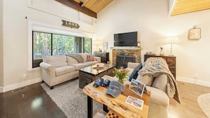 A spacious living room with a fireplace, a large TV, and a cozy seating area. - Near Ski, Beach, & Hiking Trails + Clubhouse Pool & Hot Tub Access Juanita Blue by Avantstay (Incline Village)