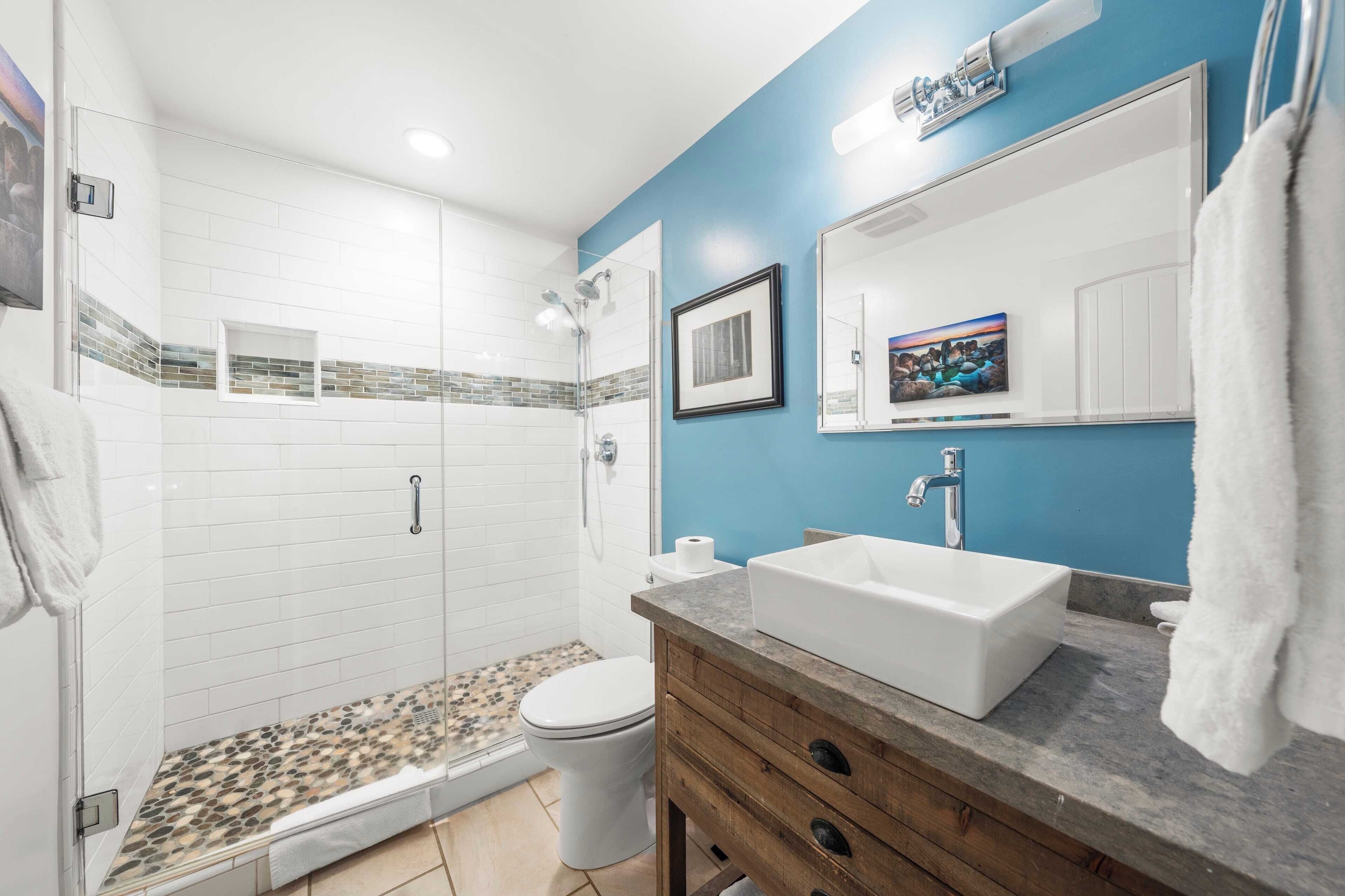 Een badkamer met douche, toilet, wastafel en badkamermeubel.