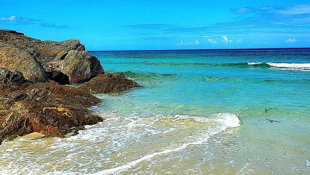 A beach with clear turquoise water, rocky shoreline, and a sandy beach. - My Rooms City Hotel Monte Blanco (Neaño)