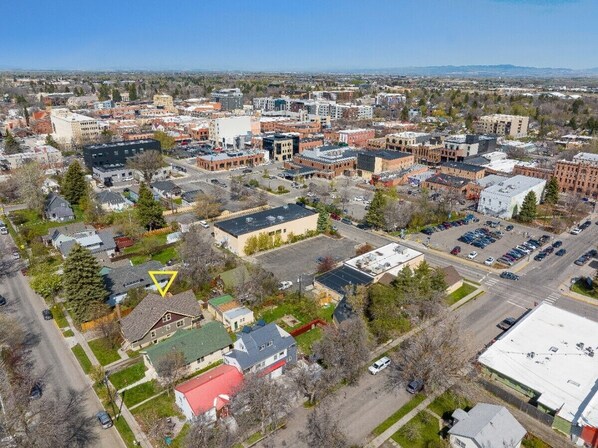 An aerial view of a cityscape with various buildings, roads, and green spaces.