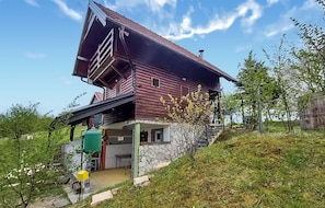 A two-story wooden house with a stone foundation, a covered porch, and a small attached garage. - Amazing home in Zorkovac with sauna (Zorkovac)