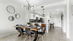 A modern kitchen with white cabinets, a central island, and pendant lighting.