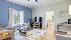 Een woonkamer met een bank, salontafel, televisie en uitzicht op de eetruimte.