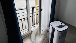 A room with a sliding glass door, a white air purifier, and a curved white chair.