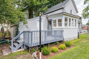 A single-story house with a covered porch, a small staircase, and a fenced yard.