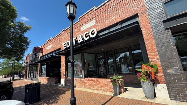A brick building with a storefront labeled "ED & CO." and a sign for "ANK" above it. - Walk to Downtown Edmond! Pet Friendly, Garage Access, King Bed! (Edmond)