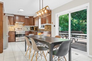 Una cocina moderna con armarios de madera, una isla central y un comedor con sillas.