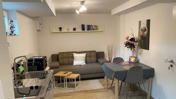 A compact living space with a kitchenette, a sofa, a dining table, and a small coffee table. - Quiet studio - charming & close to the city by bus (Bissendorf)