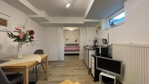 A compact living space with a dining area, kitchenette, and a TV. - Quiet studio - charming & close to the city by bus (Bissendorf)