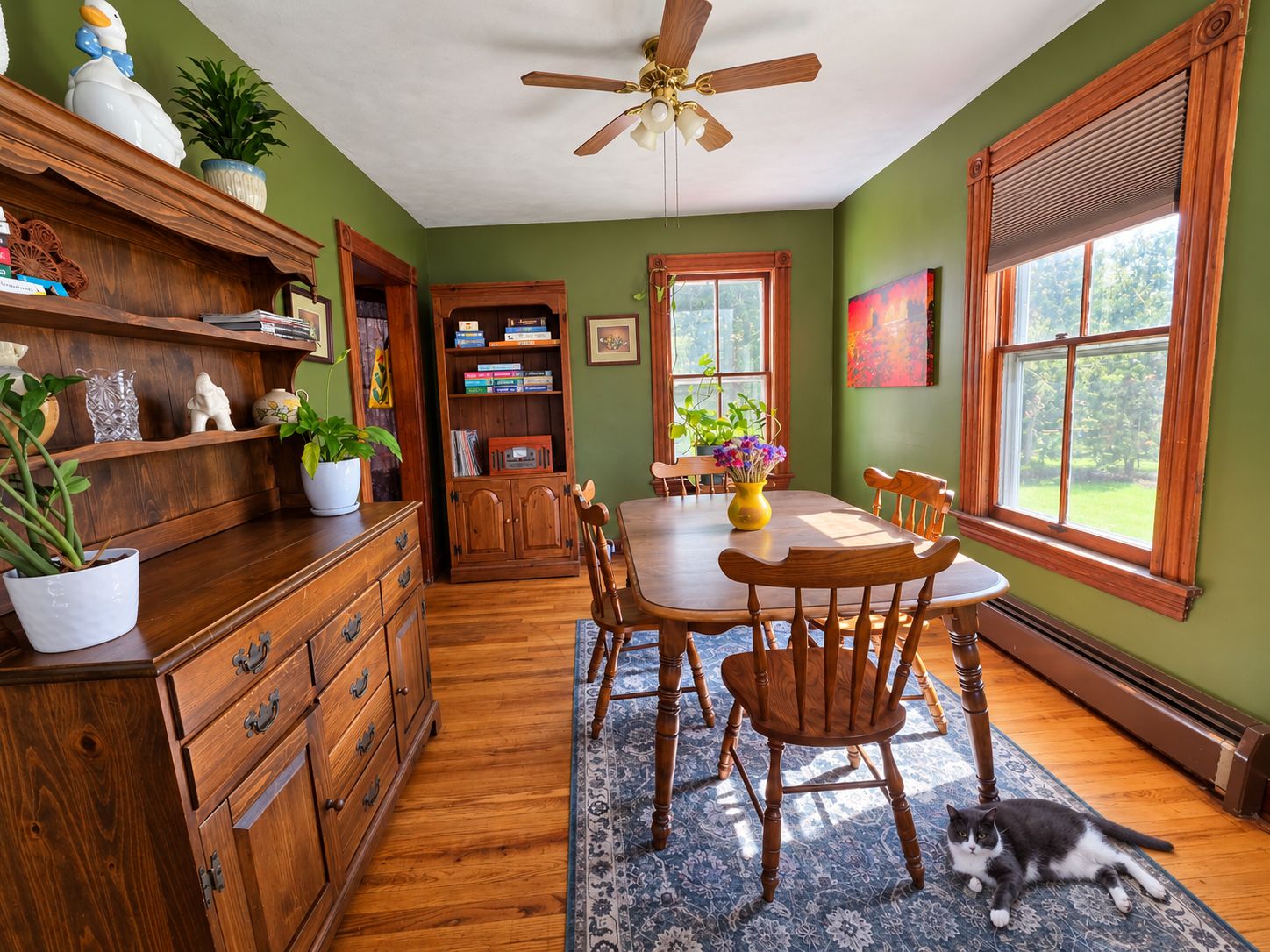 A dining area with a wooden table, chairs, and a ceiling fan.