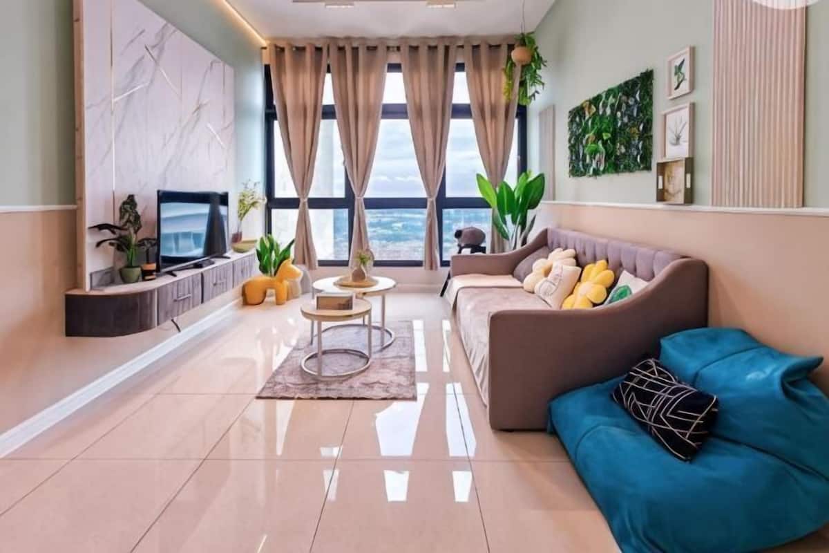 Een moderne woonkamer met een bank, televisie en sierplanten.