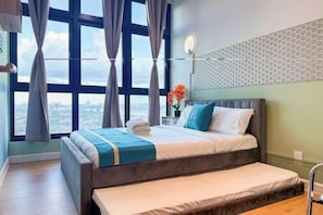 A modern bedroom with a large bed, a view of the city, and a geometric-patterned wall. - JB Paradigm Mall by RR JBcity (Tebrau)