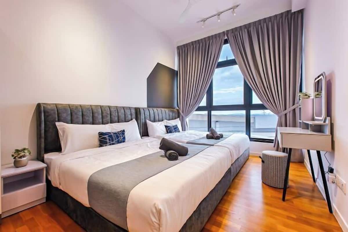 Een moderne hotelkamer met een groot bed, een bureau, een stoel en een raam met gordijnen.