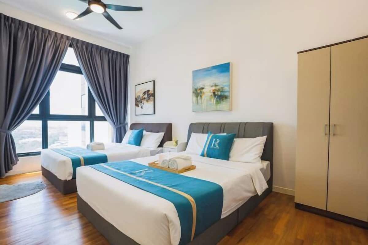 Een hotelkamer met twee bedden, een kledingkast, een plafondventilator en kunstwerken aan de muur.