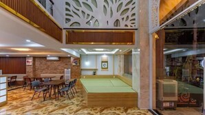 A spacious indoor area with a billiards table, seating arrangements, and a decorative wall. - Edoya Hotel Phu My Hung (Ho Chi Minh City)