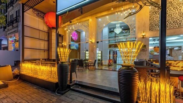 A restaurant with a modern interior, featuring a glass facade, decorative lighting, and a seating area with tables and chairs. - Edoya Hotel Phu My Hung (Ho Chi Minh City)