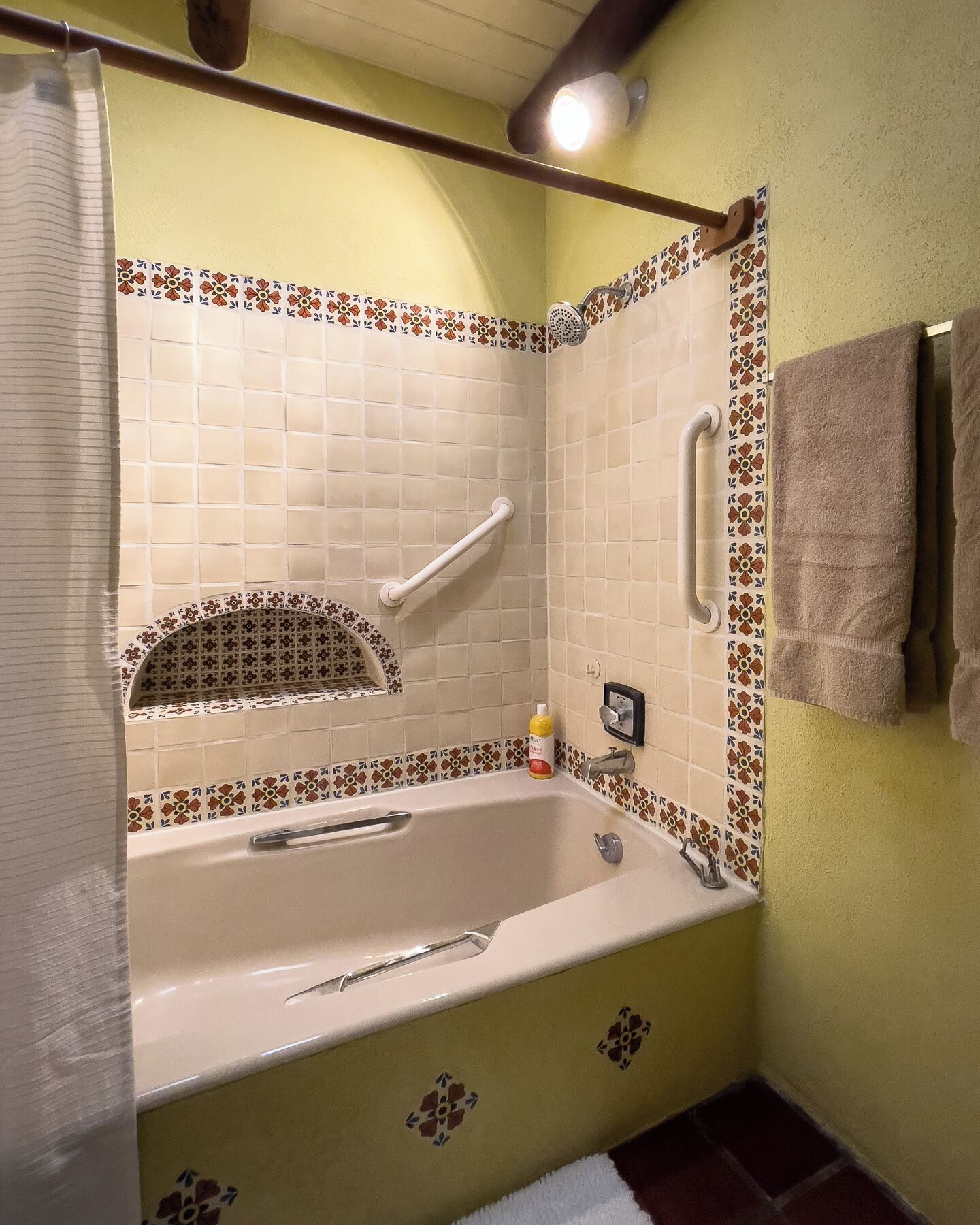 A bathroom with a bathtub, a shower, and a towel rack.