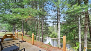 Un espace de pique-nique offrant une vue sur une rivière et une forêt.