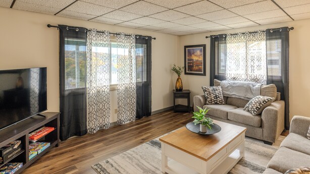 A living room with a TV, sofa, and coffee table. - Greenleaf-Summer in the U.P. • Minutes to Hancock Beach & Trails (Hancock)