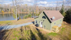 A green house with a sloped roof, a satellite dish, and a small shed. - Craftsman Cottage: Your Perfect Summer Cottage — Swim, Paddle & Relax (Iron Mountain)