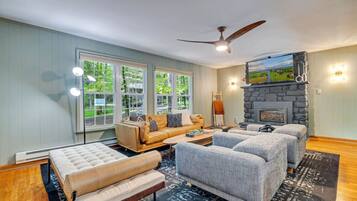 A living room with a sofa, two armchairs, a coffee table, and a fireplace.