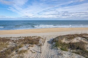 A beach with a sandy path leading to the ocean, surrounded by dunes. - The Ranch: Updated Oceanside home in Duck, Close to Beach w/Views! (Duck)