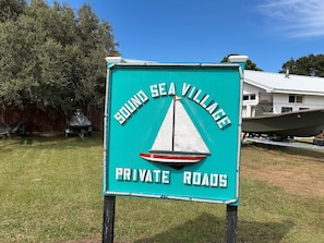 A sign for Sound Sea Village with a sailboat graphic and text indicating private roads. - The Ranch: Updated Oceanside home in Duck, Close to Beach w/Views! (Duck)