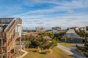 A residential area with houses, a wooden staircase, and a clear sky. - The Ranch: Updated Oceanside home in Duck, Close to Beach w/Views! (Duck)