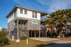 A two-story building with a wooden exterior, a balcony, and a staircase leading to an upper level.